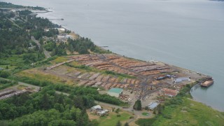 AX56_075 - 5K aerial stock footage approach lumber yard beside the Columbia River in Warrenton, Oregon