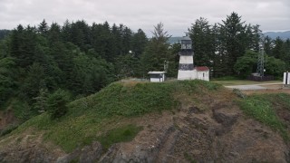 AX56_099 - 5K aerial stock footage approach and track the Cape Disappointment Light on top of a steep cliff in Washington