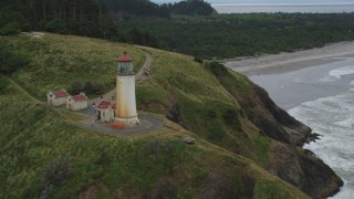 AX56_108 - 5K aerial stock footage track the North Head Light on a cliff overlooking the ocean in Ilwaco, Washington