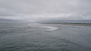AX56_126E - 5K aerial stock footage of crashing ocean waves near an empty beach in Seaview, Washington
