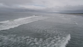 AX56_129 - 5K aerial stock footage of crashing waves near a beach in Seaview, Washington