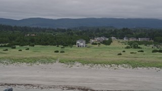 AX56_133 - 5K aerial stock footage of homes and green fields near the beach in Long Beach, Washington
