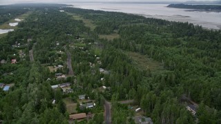 AX56_147 - 5K aerial stock footage of rural neighborhood nearly hidden by evergreens near Willapa Bay, Oceanside, Washington