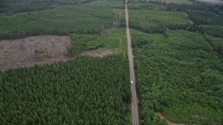AX56_157 - 5K aerial stock footage of Highway 101 through evergreen forest in Nemah, Washington