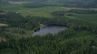 AX57_031 - 5K aerial stock footage of forest surrounding Panhandle Lake and a campground with docks in Shelton, Washington