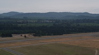 AX57_040 - 5K aerial stock footage of a skydiver landing at Sanderson Field in Shelton, Washington