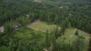AX58_026E - 5K aerial stock footage fly over forest and rural homes in Vaughn, Washington