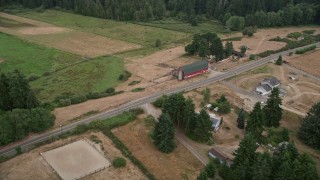 AX58_043 - 5K aerial stock footage farm with a large red barn by a country road in Gig Harbor, Washington