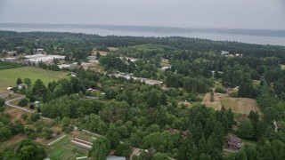 AX58_061E - 5K aerial stock footage fly over small farms and rural homes on the way to the shore of Vashon Island, Washington