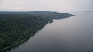 AX58_064 - 5K aerial stock footage of evergreen forest covering the shore of Vashon Island, Washington