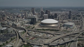 AX59_040 - 5K aerial stock footage fly over freeway interchange to approach Superdome, Downtown New Orleans skyscrapers in Louisiana