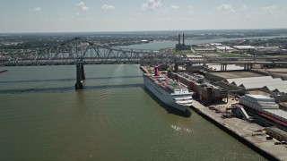 AX59_043 - 5K aerial stock footage of cruise ship docked beside the Crescent City Connection Bridge, New Orleans, Louisiana
