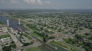 AX59_048 - 5K aerial stock footage of barges in Industrial Canal and Lower Ninth Ward homes in New Orleans, Louisiana