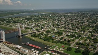 AX59_048E - 5K aerial stock footage of barges in Industrial Canal and Lower Ninth Ward homes in New Orleans, Louisiana