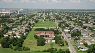 AX59_056 - 5K stock footage aerial video fly over abandoned school to approach homes in the Lower Ninth Ward, New Orleans, Louisiana