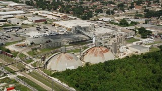 AX59_064 - 5K aerial stock footage of two industrial silos and factory in New Orleans East, Louisiana
