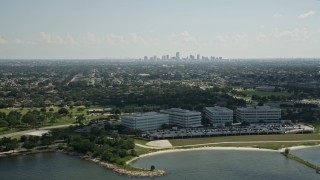 AX60_002 - 5K aerial stock footage of office buildings by Lake Pontchartrain, and view of Downtown New Orleans skyline, Louisiana