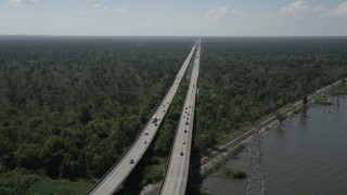AX60_008 - 5K aerial stock footage track light traffic on Interstate 10, and ascend to a wider view of the freeway and swampland in Norco and LaPlace, Louisiana