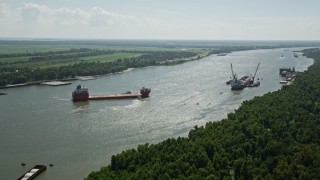 AX60_014E - 5K aerial stock footage approach and tilt to a cargo ship on Mississippi River, Louisiana