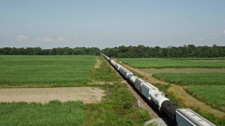 AX60_063 - 5K aerial stock footage fly over train cars and sugar cane fields in Vacherie, Louisiana