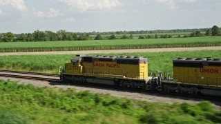 AX60_067 - 5K aerial stock footage of tracking a train speeding past sugar cane fields, Edgard, Louisiana