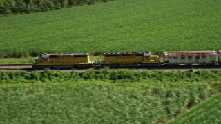 AX60_068 - 5K aerial stock footage track a train racing by sugar cane fields, Edgard, Louisiana
