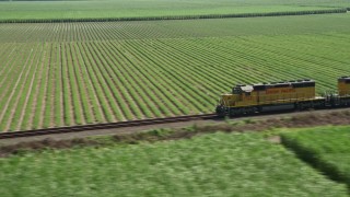 AX60_069 - 5K aerial stock footage track a train passing by sugar cane fields, Edgard, Louisiana