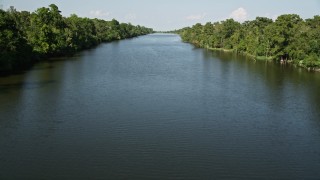 AX60_071 - 5K aerial stock footage follow a river bordered by swamps and trees, St. John the Baptist Parish, Louisiana