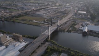 AX61_003 - 5K aerial stock footage of cars crossing Danziger Bridge, spanning Industrial Canal at sunset, New Orleans, Louisiana