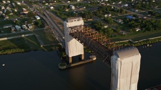 AX61_006 - 5K aerial stock footage of Claiborne Avenue Bridge spanning Industrial Canal at sunset, New Orleans