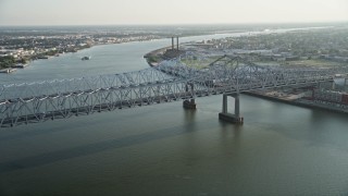 AX61_008 - 5K aerial stock footage approach Crescent City Connection Bridge spanning Mississippi River at sunset, New Orleans