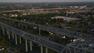 AX61_020 - 5K aerial stock footage fly over the convention center to track cars on Crescent City Connection Bridge at sunset, New Orleans, Louisiana