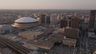 AX61_027 - 5K aerial stock footage flyby Plaza Tower to approach Superdome and New Orleans Arena at sunset, New Orleans, Louisiana