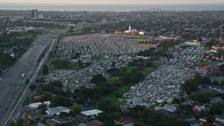 AX61_030E - 5K aerial stock footage of Greenwood Cemetery and First Baptist New Orleans church at sunset, Lakeview, Louisiana