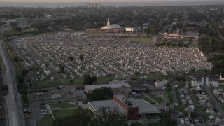 AX61_031 - 5K aerial stock footage fly over Greenwood Cemetery tombs and approach the church at sunset, New Orleans, Louisiana