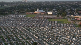 AX61_032 - 5K aerial stock footage fly over Greenwood Cemetery toward First Baptist New Orleans Church at sunset, Louisiana