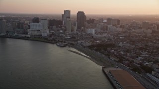 AX61_050E - 5K aerial stock footage of Downtown New Orleans at sunset, seen from the French Quarter and the Mississippi River, Louisiana