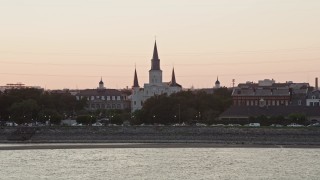 AX61_056E - 5K aerial stock footage approach St. Louis Cathedral from the Mississippi River at sunset, French Quarter, New Orleans, Louisiana