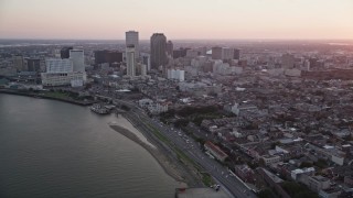 AX61_063 - 5K aerial stock footage of skyscrapers in Downtown New Orleans seen from the Mississippi River at sunset, Louisiana