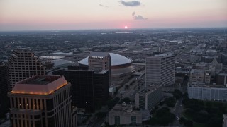 AX61_075 - 5K aerial stock footage fly over Superdome and approach freeway interchange at sunset, New Orleans, Louisiana