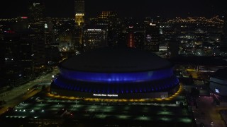 AX62_005 - 5K aerial stock footage approach Superdome and skyscrapers at night, Downtown New Orleans, Louisiana