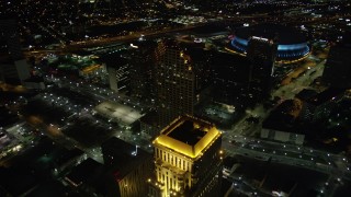 AX62_011 - 5K aerial stock footage fly over skyscrapers and approach the Superdome in Downtown New Orleans at night, Louisiana