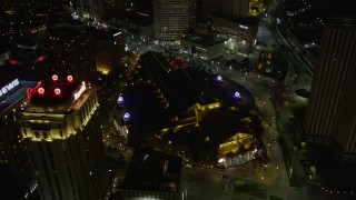 AX62_018 - 5K aerial stock footage follow Convention Center Boulevard to approach hotels and Harrah's casino in Downtown New Orleans at night, Louisiana