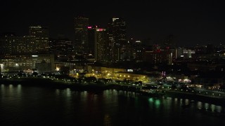 AX62_030 - 5K aerial stock footage of Downtown New Orleans skyscrapers seen from the Mississippi River at night, Louisiana