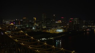 AX62_032 - 5K aerial stock footage reverse view of Downtown New Orleans at night, reveal Crescent City Connection, Louisiana