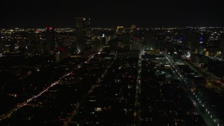 AX62_040 - 5K aerial stock footage of Bourbon Street and Downtown New Orleans at night seen from the French Quarter, Louisiana