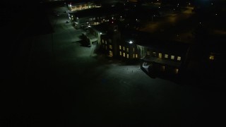 AX62_052 - 5K aerial stock footage of the main terminal of New Orleans Lakefront Airport at night, Louisiana