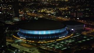 AX63_020 - 5K aerial stock footage orbit the Superdome as it changes colors at night, New Orleans, Louisiana