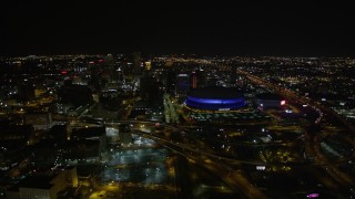AX63_027 - 5K aerial stock footage of a reverse view  Superdome and Downtown New Orleans at night in Louisiana