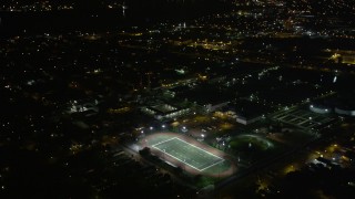 AX63_035 - 5K aerial stock footage fly over homes to approach Harrell Stadium at night, Carrollton, New Orleans, Louisiana